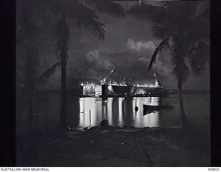 PACIFIC OCEAN. C.1945. WORK IS CARRIED OUT ON SHIP AT NIGHT IN AN ADVANCED BASE SECTIONAL DOCK OF THE US NAVY AT A PACIFIC ISLAND BASE. (NAVAL HISTORICAL COLLECTION)