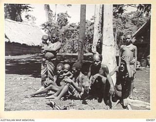SIPILANGAN, NEW BRITAIN, 1945-07-27. A GROUP OF NATIVE REFUGEES, WHICH INCLUDES THE VERY YOUNG AND THE VERY OLD, AT THE AUSTRALIAN NEW GUINEA ADMINISTRATIVE UNIT REFUGEE CAMP IN THE WIDE BAY AREA. ..
