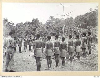 KIARIVU, NEW GUINEA, 1945-08-17. THE BURIAL CEREMONY OF A NATIVE SOLDIER OF 2 NEW GUINEA INFANTRY BATTALION WHO DIED OF WOUNDS SUFFERED IN THE INITIAL ATTACK ON KIARIVU. A GUARD OF HONOUR DRAWN ..