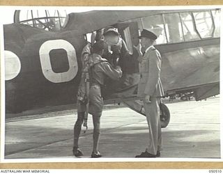 LAVERTON, VIC. 1943-04. WING-COMMANDER TOWNSEND OF 67 SQUADRON, RAAF AFTER BRIEFING THE PILOT AND AIR CREW, WATCHES THEM BOARD THE AIRCRAFT FROM WHICH THEY WILL DROP SUPPLY-CONTAINERS ON TO A ..