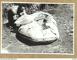 RAMU VALLEY, NEW GUINEA. 1943-12-21. QX55419 SAPPER M. F. HOURIGAN OF THE 53RD AUSTRALIAN FIELD PARK COMPANY, ROYAL AUSTRALIAN ENGINEERS, 7TH AUSTRALIAN DIVISION, TESTING A RAFT INFLATION BLADDER ..