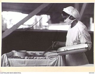 BOUGAINVILLE, 1945-06-18. SISTER I.B. SCHULTZ, ARRANGING INSTRUMENTS IN THE OPERATING THEATRE, 109 CASUALTY CLEARING STATION, BEFORE AN OPERATION. (A GENERAL VIEW OF THE SURGICAL WARD, 109 CASUALTY ..