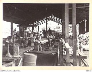 LAE, NEW GUINEA. 1944-12-21. THE INTERIOR OF THE BUSU MILL OPERATED BY 2/3 FORESTRY COY MEMBERS SHOWING THE LENGTH OF THE BUILDING AND SOME OF THE EQUIPMENT USED
