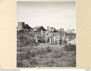 CAPE WOM, WEWAK AREA, NEW GUINEA. 1945-08-29. MEMBERS OF 110 BRIGADE WORKSHOP, CORPS OF AUSTRALIAN ELECTRICAL AND MECHANICAL ENGINEERS, TAKING SHOWERS. A JAPANESE WATER TANK SUPPLIES THE WATER