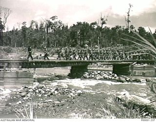 THE SOLOMON ISLANDS, 1945-09-19. JAPANESE TROOPS FROM NAURU ISLAND, UNDER AUSTRALIAN GUARDS, CROSSING A BRIDGE ON THEIR WAY FROM TOROKINA TO AN INTERNMENT CAMP ON BOUGAINVILLE ISLAND. (RNZAF ..