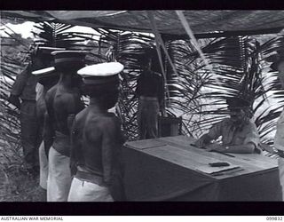 LAE, NEW GUINEA, 1946-02-14. FOUR VILLAGE HEADMEN BEING ADDRESSED BY MAJOR GENERAL B.M. MORRIS, GENERAL OFFICER COMMANDING, AUSTRALIAN NEW GUINEA ADMINISTRATIVE UNIT. AT A SPECIAL PARADE, MAJOR ..