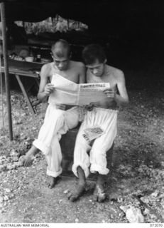 HELDSBACH PLANTATION, NEW GUINEA. 1944-04-06. JAPANESE PRISONERS OF WAR AT THE 106TH CASUALTY CLEARING STATION WHO CAN READ ENGLISH SPEND MUCH OF THEIR TIME IMPROVING THEIR KNOWLEDGE OF THE ..