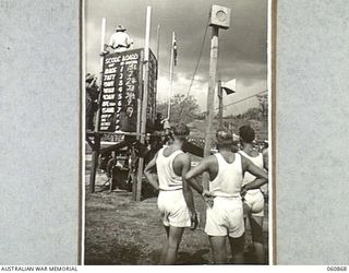 NEW GUINEA. 1943-11-20. SCORE BOARDS, FACING THREE DIRECTIONS, WHICH WERE ERECTED FOR THE CHAMPIONSHIPS SPORTS MEETING ORGANISED BY THE 18TH AUSTRALIAN INFANTRY BRIGADE TO CELEBRATE THE FOURTH ..