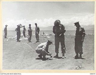 MALAHANG BEACH, LAE, NEW GUINEA. 1945-10-16. TROOPS OF FIRST ARMY DESTROYED SURPLUS AMMUNITION AT MALAHANG BEACH. THEY ARE SHOWN LAYING A FUSE TRAIL