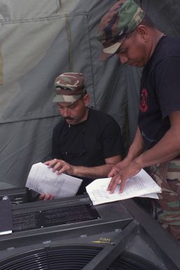 U.S. Air Force STAFF SGT. Rafael Diaz and TECH. SGT. Raymond Susuico from Guam, deployed to the 3rd Air Expeditionary Group at Kwang-Ju Air Base Republic of Korea, repair an environmental control unit in tent city pm Sept. 3, 2004. (U.S. Air Force photo by Technical Sergeant Corey A. Clements) (Released)