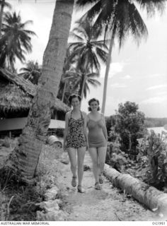 MADANG, NEW GUINEA. C. 1944-10. WOMEN OUT OF UNIFORM, SISTER B. FUREY, NEWCASTLE, NSW AND SISTER M. WHITCOMBE, SYDNEY, NSW, WALK DOWN TO THE BEACH FOR A SWIM AFTER DUTY IN A MEDICAL RECEIVING ..