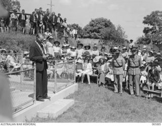 HERBERTON, QLD. 1944-04-25. MR. G. FURLONG, PRESIDENT OF THE LOCAL BRANCH OF THE RETURNED SAILORS, SOLDIERS AND AIRMEN'S IMPERIAL LEAGUE OF AUSTRALIA DELIVERING AN ADDRESS FROM THE STEPS OF THE WAR ..