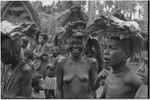 Mortuary ceremony, Omarakana: mourning women, their heads shaved, carry banana leaf bundles (wealth items) for ritual exchange