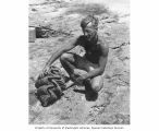 Dr. Arthur D. Welander, radiobiologist, with a giant clam, Bikini Atoll, summer 1947