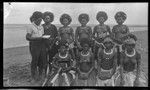 Men and women of Gaile, a Motu village, holding books and photographs; women wearing kina, crescent shell valuable necklace