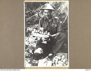 FARIA VALLEY, NEW GUINEA, 1943-10-16. SX8758 PRIVATE R.A. OPPERMAN OF THE QUARTERMASTER'S STORE, 2/27TH AUSTRALIAN INFANTRY BATTALION WITH WASHING, SHAVING AND TOILET SOAPS FOR ISSUE TO THE TROOPS ..