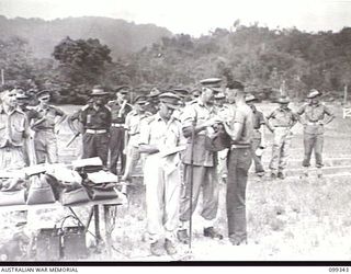 TOROKINA, BOUGAINVILLE, 1945-12-05. MAJOR-GENERAL W. BRIDGEFORD, GENERAL OFFICER IN CHARGE 3 DIVISION PRESENTING THE PRIZE TO SERGEANT R. SNODGRASS, 12 ADVANCED WORKSHOP FOR WINNING THE 880 YARDS ..