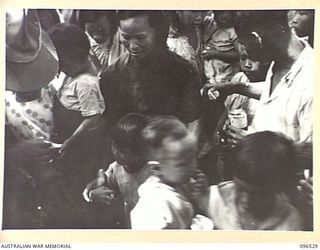 RABAUL AREA, NEW BRITAIN. 1945-09-13. CHINESE CIVILIANS, INTERNED BY THE JAPANESE AT A CAMP 15 MILES WEST OF RABAUL, WERE CONTACTED BY A PARTY OF AUSTRALIAN ARMY AND RED CROSS OFFICIALS SOON AFTER ..