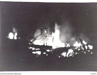 LAE, NEW GUINEA. 1944-09-13. A NIGHT PHOTOGRAPH OF THE BASE STORES DEPOT BEING BURNT OFF PRIOR TO THE AUSTRALIAN TROOPS MOVING OUT OF THE AREA