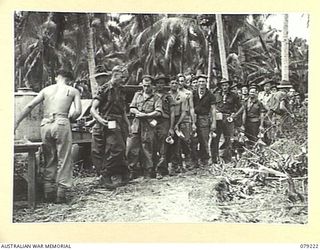 KALAI PLANTATION, NEW BRITAIN. 1945-02-21. TROOPS OF THE 6TH INFANTRY BRIGADE LINE UP FOR THEIR TEA AND BISCUITS AT THE YOUNG MEN'S CHRISTIAN ASSOCIATION-AUSTRALIAN COMFORTS FUND STALL DURING A ..