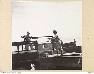 KAIRIRU ISLAND, NEW GUINEA, 1945-09-11. JAPANESE SOLDIERS UNLOADING AND TRANSFERRING THE BELONGINGS OF REAR-ADMIRAL SATO FROM A JAPANESE TO AN AUSTRALIAN TRUCK, DURING THE TRANSFER OF AN ADVANCE ..