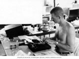 Historian Hill Williams at his typewriter, Enewetak Atoll, summer 1964