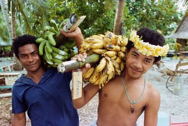 Men carrying bananas, Tokelau