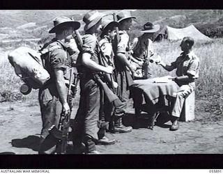 WAU AREA, NEW GUINEA. 1943-08-16. SOLDIERS CASTING THEIR VOTES IN THE FEDERAL ELECTION BEFORE MOVING UP TO THE FRONT LINE. LEFT TO RIGHT:- VX105681 SIGNALLER G. H. RADFORD, 3RD AUSTRALIAN DIVISION ..