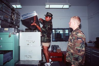 Machinist Mate Second Class (MM2) Robert Scott and Photographers Mate Second Class (PH2) Steve Babylon break out their cased sniper rifles from the armory at Naval Activities Guam shooting range. Both men are members of Naval Special Warfare Unit One-SEAL Team Five