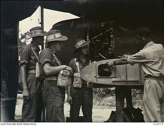 TOROKINA, BOUGAINVILLE ISLAND, SOLOMON ISLANDS. 1945-01-19. 6378 FLIGHT SERGEANT D. O. PATTEN OF EPPING, NSW, EXPLAINING TO MEMBERS OF AIF HOW THE MAINPLANE IS CONNECTED TO THE CENTRE SECTION OF AN ..