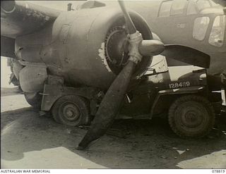Tadji, New Guinea. 1945-01-20. A badly smashed Australian Army jeep under the starboard engine of A9-557, a Bristol Beaufort bomber operated by No 100 Squadron RAAF. This aircraft returned from a ..