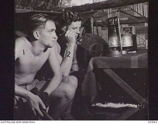 UBERI, NEW GUINEA. 1943-07-08. IN ORDER TO MAINTAIN A CONTINUOUS SERVICE, TELEPHONE LINES MUST BE TESTED EVERY HOUR. N220047 SIGNALMAN S. C. WILLIAMS, LEFT, AND VX114353 SIGNALMAN F. A. BANAMAN OF ..