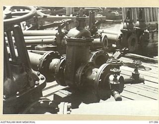 PORT MORESBY, PAPUA, 1944-03-21. PIPES LEADING TO THE END OF THE WHARF, USED BY THE 1ST BULK PETROLEUM STORAGE COMPANY, (NEW GUINEA FORCE), TO CONNECT TO SHIPS. SHOWN FROM LEFT TO RIGHT ARE: MAIN ..