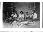 Portrait of native Hawaiian family sitting on the floor eating poi, Hawaii, 1907