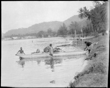 Laden canoe on the beach with three people, New Guinea, ca. 1929 / Sarah Chinnery