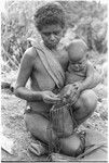 Fulabata (Batalamo's wife) and child, getting tobacco from bag