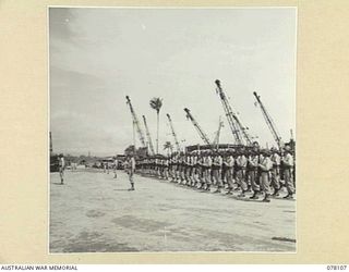 TOROKINA, BOUGAINVILLE ISLAND. 1944-12-15. AMERICAN TROOPS PRESENT ARMS AS MAJOR GENERAL O.W. GRISWOLD, COMMANDING GENERAL, 14TH UNITED STATES CORPS ARRIVES AT NO 4 WHARF TO BOARD A SHIP FOR HOME