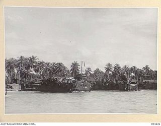 AITAPE BEACH HEAD, NEW GUINEA. 1945-06-19. LANDING CRAFT TANKS LINED UPON THE BEACH, WHILE BEING LOADED BY MEMBERS OF 7 DOCKS OPERATING COMPANY, ROYAL AUSTRALIAN ENGINEERS, WITH STORES AND SUPPLIES ..