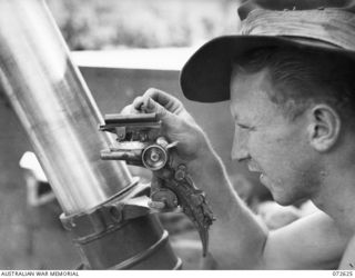 WANDOKAI, NEW GUINEA. 1944-04-22. NX161748 PRIVATE D.C. MOLLOY, NO. 1 MEMBER OF A MORTAR CREW, WITH THE 101ST BRIGADE SUPPORT COMPANY SETTING THE SIGHTS OF A 4.2 INCH MORTAR MOUNTED IN A LCM ..