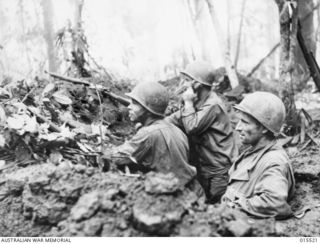 1943-08-11. NEW GUINEA. MOUNT TAMBU FIGHTING. AN AMERICAN OBSERVATION POST ON THE SIDE OF MOUNT TAMBU. IN THE POST THE MUD WAS EIGHTEEN INCHES DEEP. LEFT TO RIGHT:- SGT. ROB. TOBEY, OF EUGENE, ..
