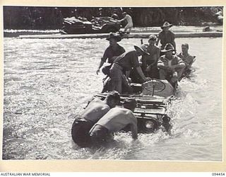 SOUTH BOUGAINVILLE. 1945-07-24. A JEEP AND TRAILER OF 6 MECHANICAL EQUIPMENT COMPANY, ROYAL AUSTRALIAN ENGINEERS, LOADED WITH TROOPS, FAILED TO CROSS THE FLOODED MOBIAI RIVER. A BULLDOZER PULLED ..