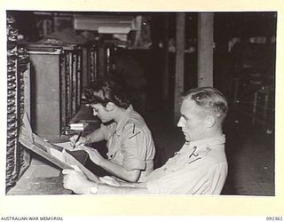 LAE, NEW GUINEA, 1945-05-23. PRIVATE P.C. RYAN, AWAS (1), WORKING WITH CORPORAL B.F. MCDOWELL (2), AT NO 3 SUB DEPOT, 4 ADVANCED ORDNANCE DEPOT. AWAS PERSONNEL ARE AT LAE TO RELEASE HQ FIRST ARMY ..