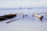 French Polynesia, children swimming by canoes off Moorea Island