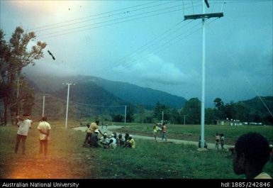 People sitting next to power lines