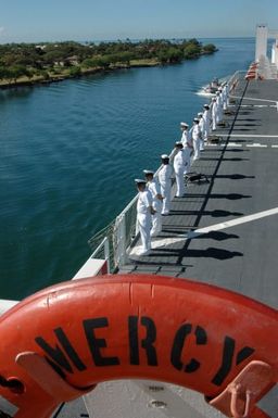 US Navy (USN) Sailors man the rails aboard the USN Military Sealift Command (MSC), Hospital Ship, USNS MERCY (T-AH 19) as the ship enters the harbor at Navy Base Pearl Harbor, Hawaii (HI). The USNS MERCY is starting a scheduled five-month deployment to deliver aid and humanitarian assistance to the Pacific Islands, and Southeast Asia.2006) Sailors of hospital ship USNS Mercy (T-AH19) man the rails as they pull into Mercy s first port visitPearl Harbor. The ship will embark a U.S. Navy Band to join them on their five month humanitarian assistance mission in the Pacific. During Mercy s deployment it will visit areas of South AsiaSoutheast Asiaand the Pacific Islands where its crew and...