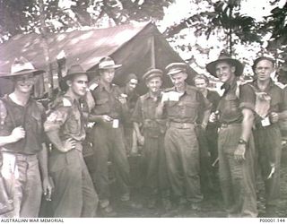 THE SOLOMON ISLANDS, 1945-05. A GROUP OF AUSTRALIAN ARMY OFFICERS RELAXING AT THEIR CAMP AT NORTH BOUGAINVILLE. (RNZAF OFFICIAL PHOTOGRAPH.)