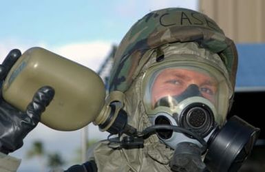 US Air Force (USAF) SENIOR AIRMAN (SRA) Ben Case, with the 154th Maintenance Squadron (MXS), hydrates with his canteen while wearing Mission Oriented Protective Posture level-4 (MOPP-4) gear, during an Operational Readiness Exercise (ORE) at a Hawaii Air National Guard (ANG) unit on Hickam Air Force Base (AFB), Hawaii (HI)