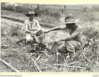 PAPUA. 1942-08. BOILING THE BILLY, NEW GUINEA STYLE. MEN OF THE 2/27TH AUSTRALIAN INFANTRY BATTALION RECENTLY RETURNED FROM THE MIDDLE EAST, MAKING TEA FOR A MEAL BEFORE BIVOUACKING FOR THE NIGHT ..