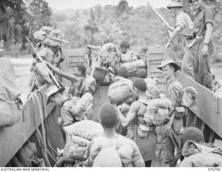 JACQUINOT BAY, NEW BRITAIN. 1944-11-06. SERGEANT T.J. CHAPPLE (1) AND SERGEANT C.O. CANNING (2) WITH THE NATIVE SOLDIERS OF B COMPANY, 1ST NEW GUINEA INFANTRY BATTALION GOING ASHORE FROM A LANDING ..