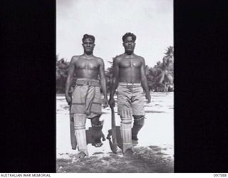 TARAWA ISLAND, GILBERT AND ELLICE ISLAND GROUP. 1945-09-27. BEIAUN AND TABUNAWATI, OPENING BATSMEN FROM THE GILBERT ISLAND CRICKET TEAM, MOVING TO THE WICKETS. THE MEN ARE TAKING PART IN A MATCH ..